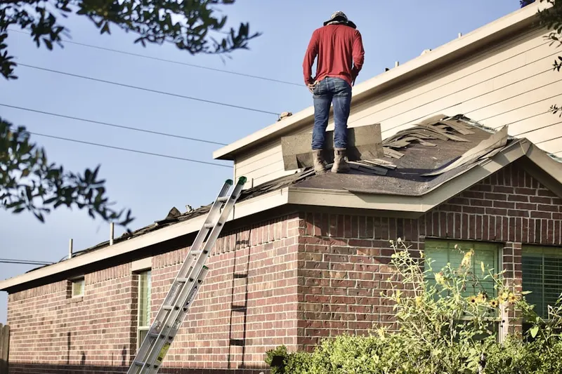 Professional roofer working on a residential roof in Bates Mill